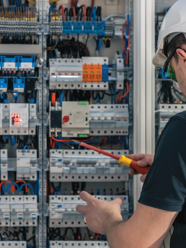 Electrician Works on Electrical Panel in the Workplace