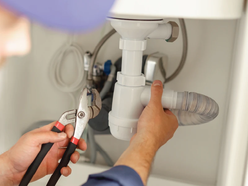 Plumber Fixing a Sink with Pliers Indoors